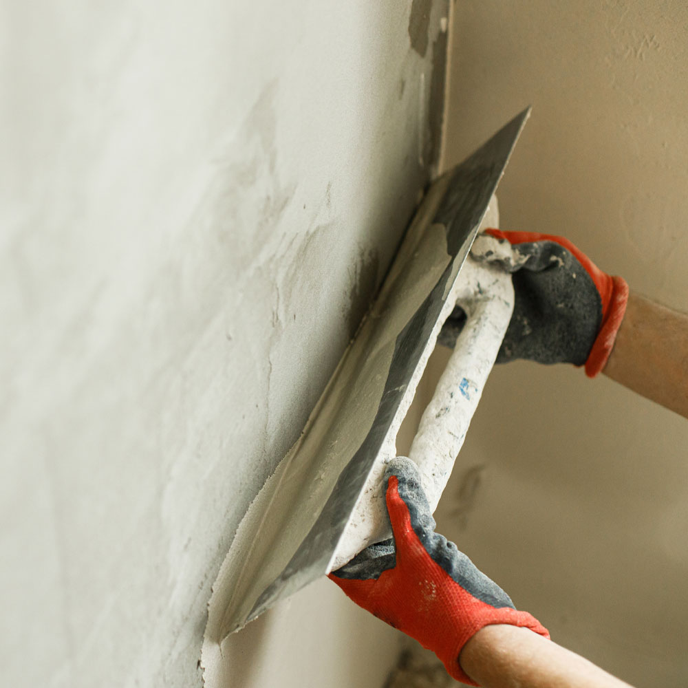Mican plastering team member smoothing out plaster on a new build property.