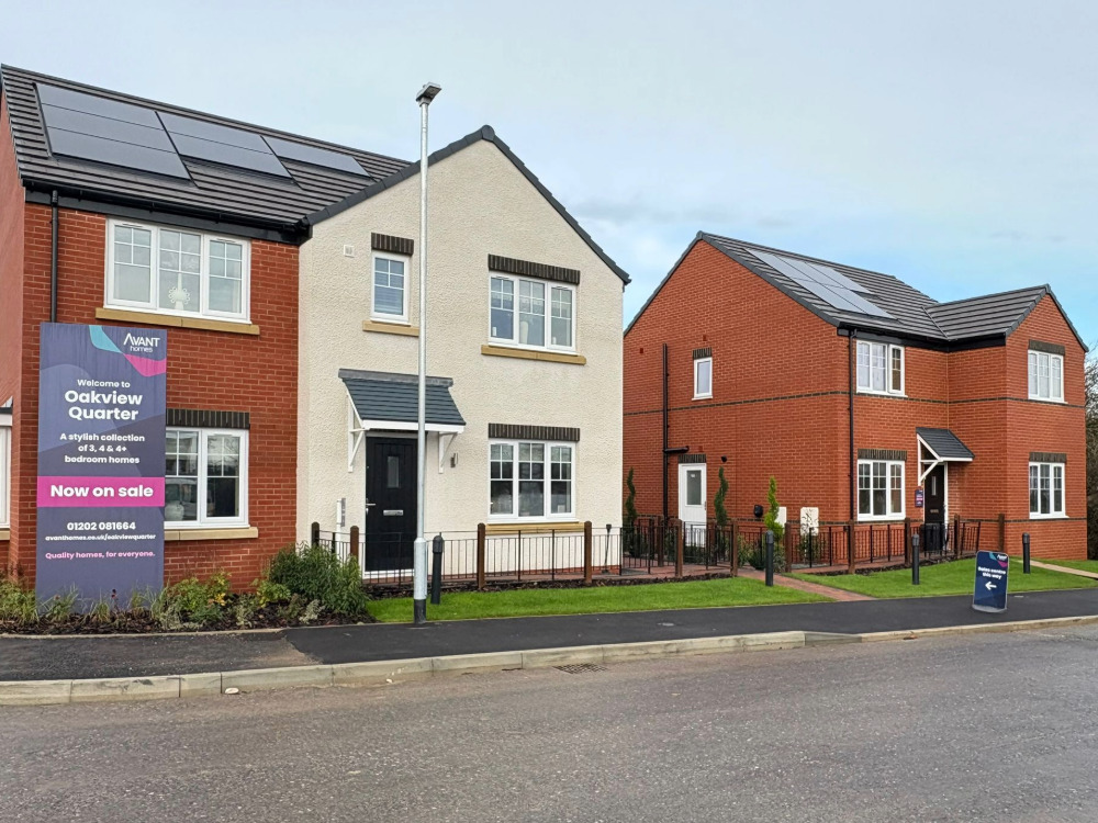 Two new build homes with dry lining and external rendering and a sign for Oakview Quarter next to the road