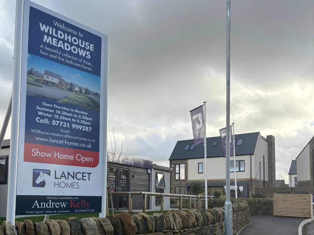 Wildhouse Meadows advertisement sign at the front of the development, including a show home in the background